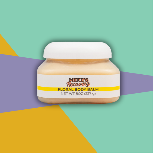 Small tub of Mike's Recovery Floral Body Balm with abstract background
