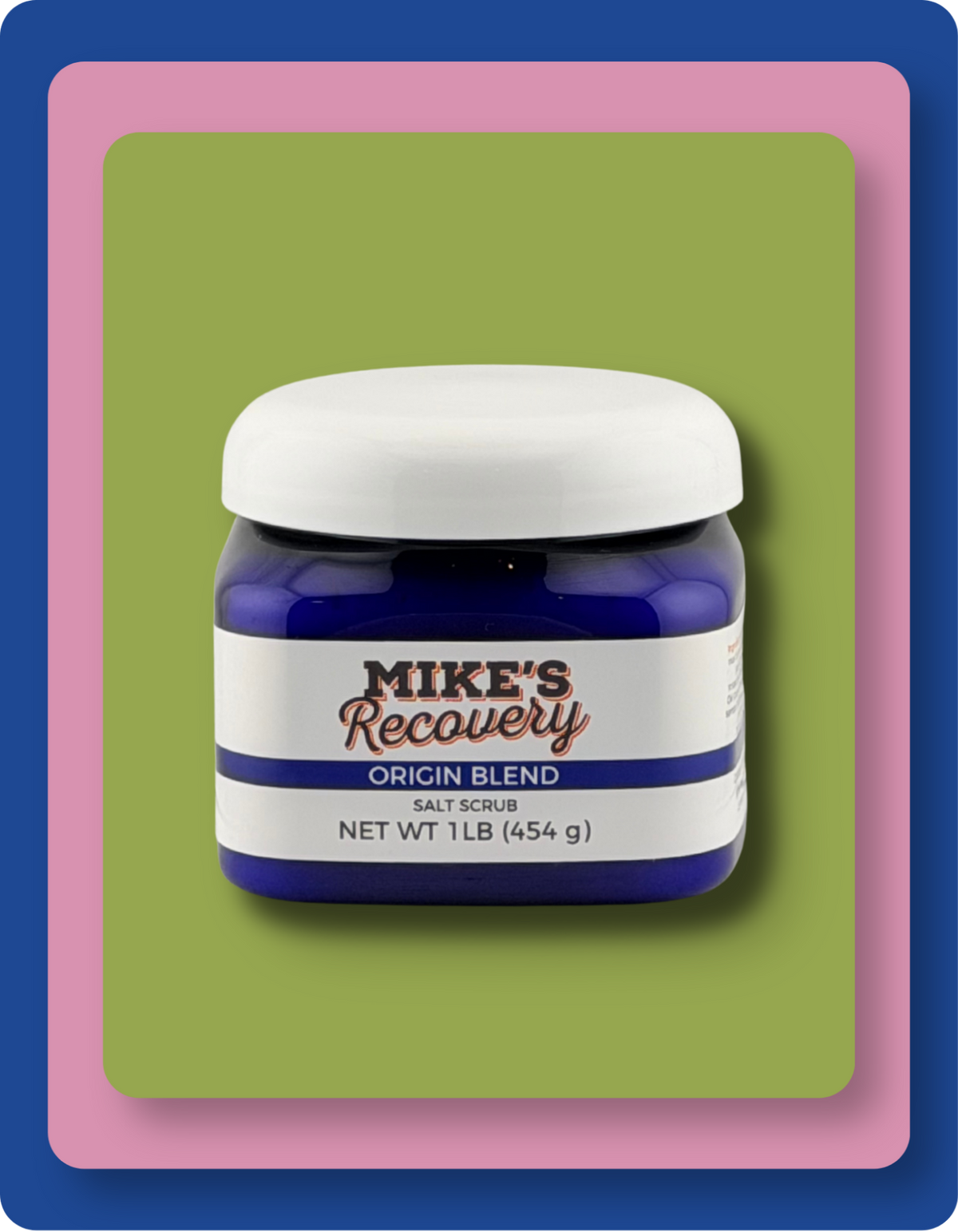 A jar of Mike's Recovery Origin Blend Salt Scrub, featuring a dark blue container, a white lid, and a white label with blue and red text, set against a layered green, pink, and blue background.