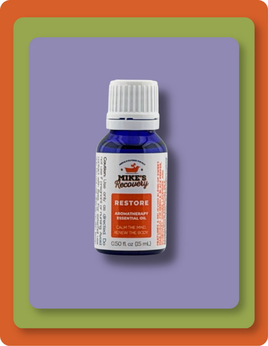 A small blue glass bottle of Mike's Recovery Restore essential oil with a white cap and white label, centered on a purple square background with green and orange border frames.